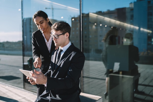 Coworking business people sharing tablet on street