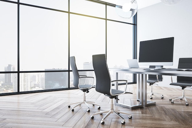 Coworking office interior with blank computers screen