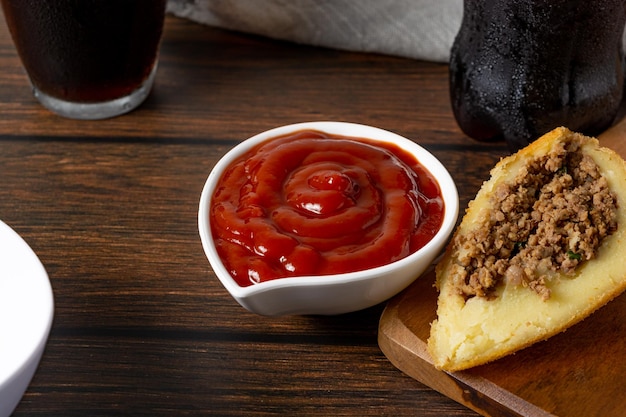 coxinha, cutted in half stuffed with meat. also ketchup sauce