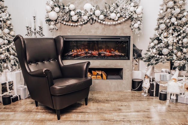 Cozy apartment, artificial electric bright fireplace with fake sparkling flame. Leather armchair