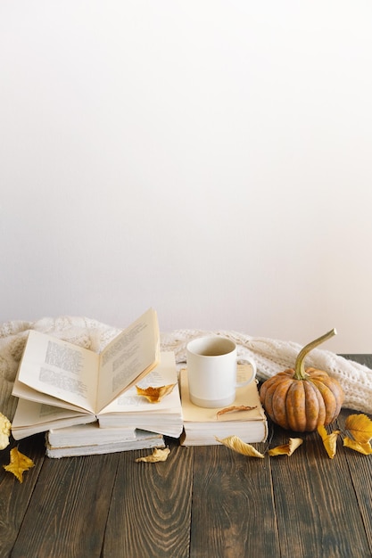 Cozy autumn background decorative pumpkin dried flowers books warm sweaters Reading in the autumn day Autumn books Autumn reading Cozy mood Space for text top view