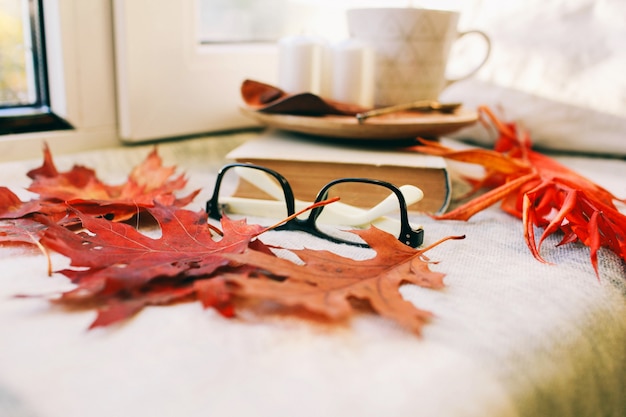 Cozy autumn morning with cup of coffee with cream and autumn leaves  Autumn and holiday concept. Flat lay Top view 