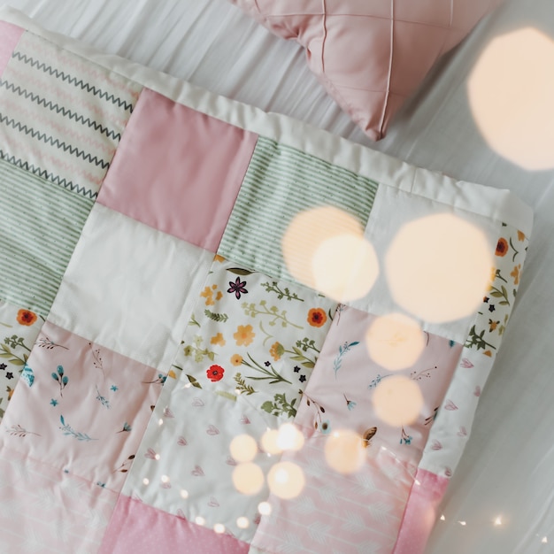 cozy baby cot with pink patchwork blanket