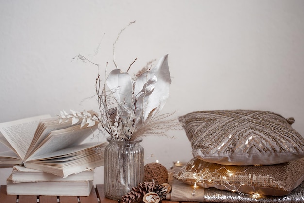 Photo cozy background with books a vase of dried flowers and decorative cushes