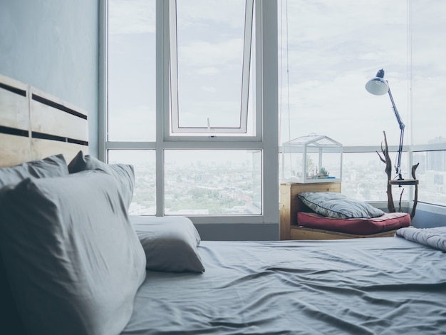 Cozy bedroom apartment with light from big windows glasses.