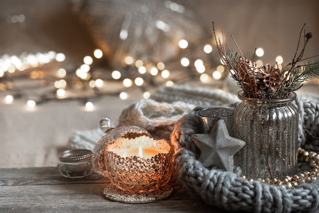 Cozy Christmas composition with burning candles in a decorative candlestick. The concept of home comfort and warmth.