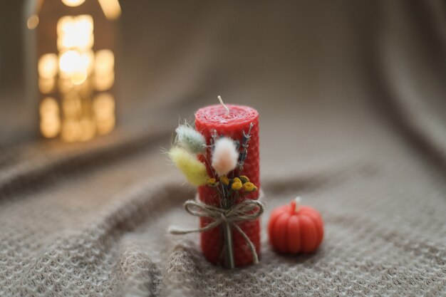 Cozy fall composition and autumn home decor with candles on warm background