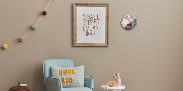 Cozy interior of child room with mint armchair brown mock up poster frame toys teddy bear plush animal decoration and hanging cotton colorful balls Beige wall Warm kid space Template