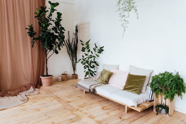 Cozy interior whith wooden sofa, wooden floor and house plants