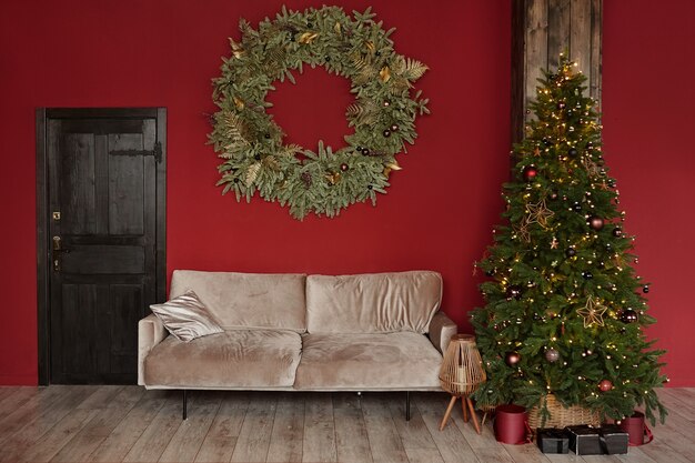 Cozy living room interior with a vintage wooden door couch decorated christmas tree and giant christ...