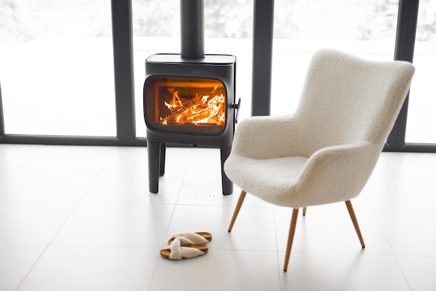 Cozy living space by the burning fireplace at snowy mountains