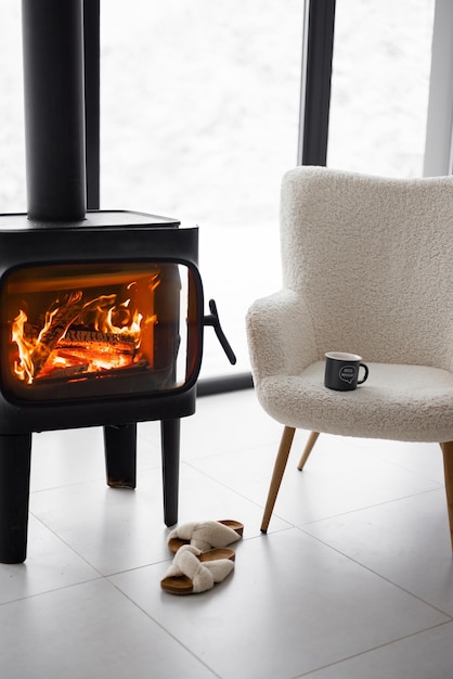 Cozy living space by the burning fireplace at snowy mountains