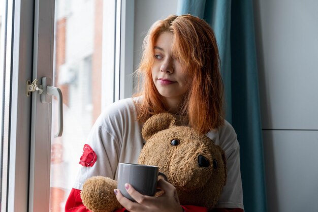 Cozy Moment of Generation Z RedHaired Teenage Girl with Hot Drink and Teddy Bear