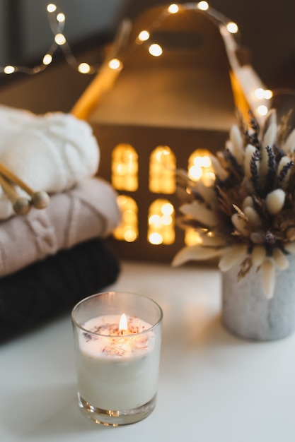 cozy still life with candle knitted sweater decorations and bokeh lights surface