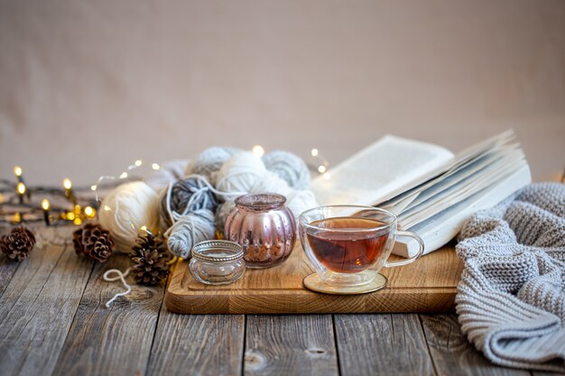 Cozy still life with tea and decorative items, glowing lights in the wall.