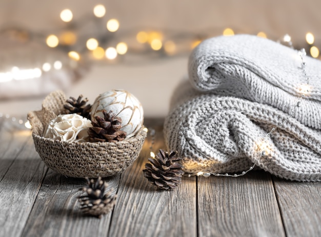 Cozy winter bokeh background with stacked sweaters and decor details.