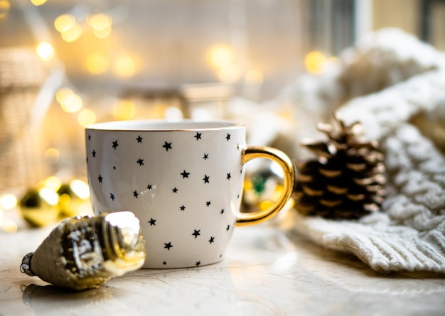 Cozy winter holiday decoration Christmas lights and coffee cup with decor details real home