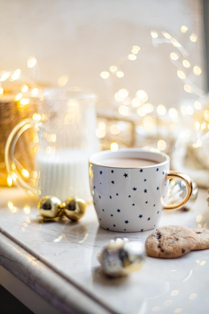 Cozy winter holiday decoration Christmas lights and coffee cup with decor details real home