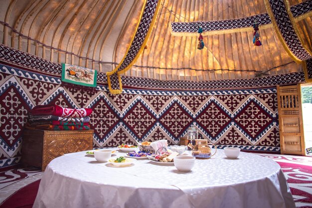 Cozy Yurt Interior with Traditional Meal Table Setup and Colorful Decor