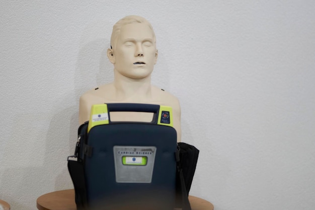 CPR chest compression and automatic external defibrillator AED training manikin - first aid concept