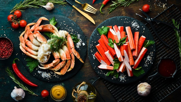 Crab sticks from a crab on a black stone plate. Rustic style. Seafood delicacies.