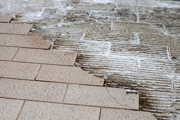 Cracked brown tiles on cement floor