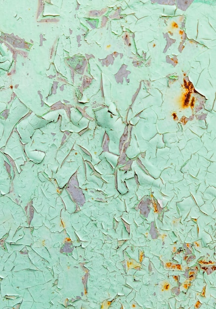 Cracked and peeling of green color paint on steel with rusted texture and background