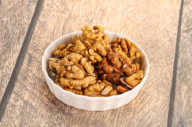 Cracked unshelled walnut in the bowl