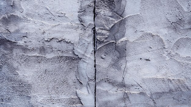 Photo cracked wall texture cement concrete floor background plaster facade house wall with grey dark cracks abstract background