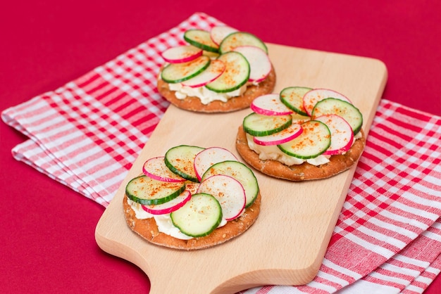 Cracker sandwich with cream cheese fresh cucumber and radish