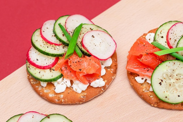 Cracker sandwiches with salmon cucumber radish cottage cheese and green onions