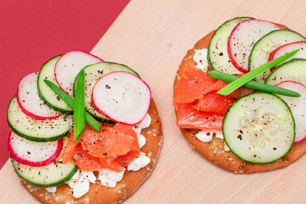 Cracker sandwiches with salmon cucumber radish cottage cheese and green onions