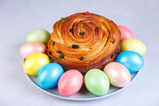 Craffin Cruffin with raisins and candied fruits Traditional Easter Bread Kulich and painted eggs on a gray background Easter Holiday Closeup selective focus