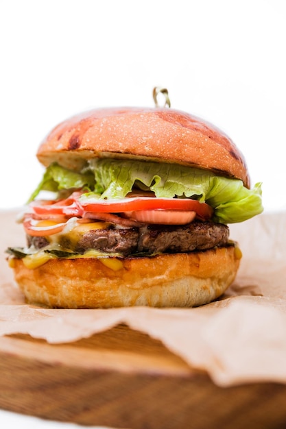 Craft beef burger on wooden plate isolated on white background