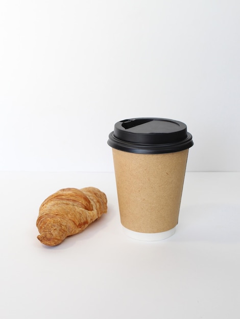 Craft coffee cup with croissant on white background French breakfast Flat lay top view