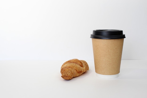 Craft coffee cup with croissant on white background French breakfast Flat lay top view