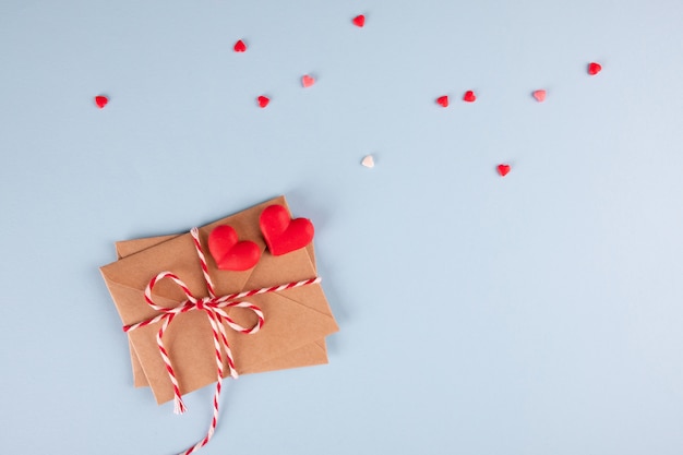 Craft envelopes with hearts on blue table