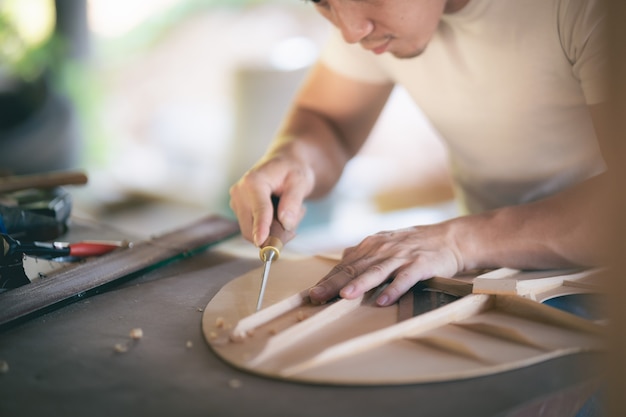 Craft man making guitar on wood table, capenter working concept