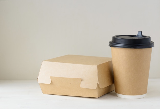 Craft paper coffee cup and food box on the white table