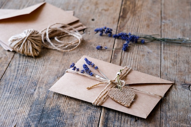 Craft paper envelope lies on a wooden background, decorated with jute rope