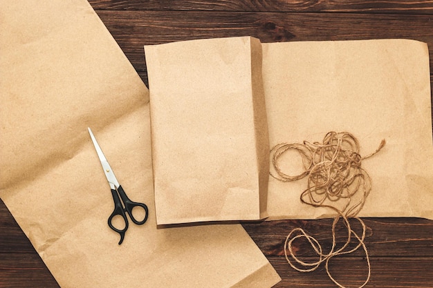 Craft paper for gift wrapping with scissors on a wooden background