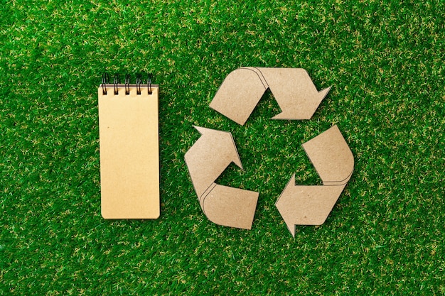 Craft paper on grass recycling concept top view