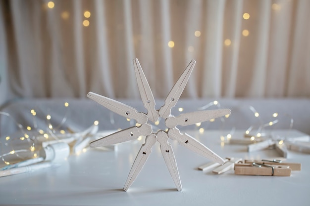 Craft wooden snowflakes from clothespins painted with white color reusable diy new year ornament