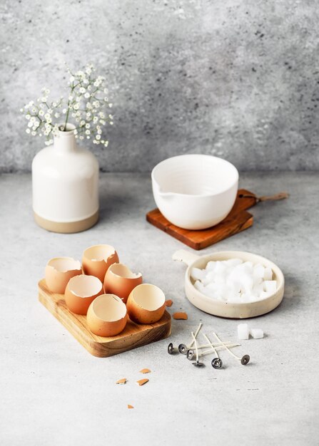 Craft workplace with eggshells and  tools to create Easter candles  decoration.