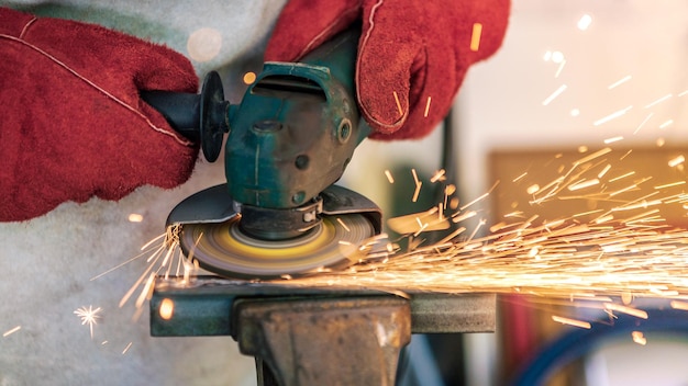 Craftsman grinding metal with disk grinder in workshop Worker cleaning a steel