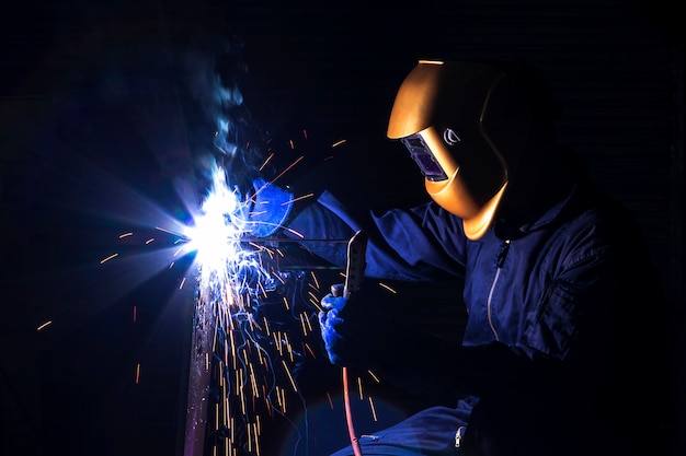 A craftsman is welding with workpiece steel.