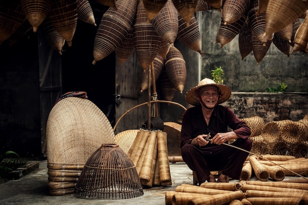 Craftsman making bamboo fish trap at old village, Hung Yen, Vietnam