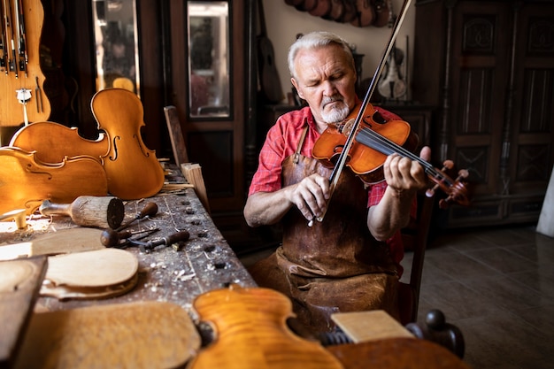 Craftsman playing violin in his carpentry's workshop