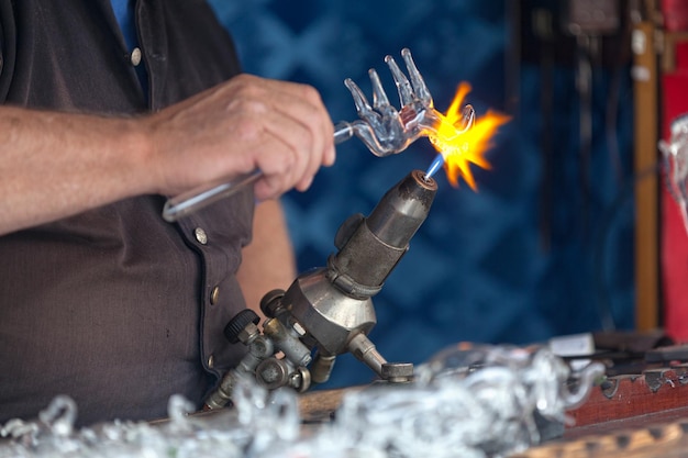 Craftsman shaping a glass horse with his torch