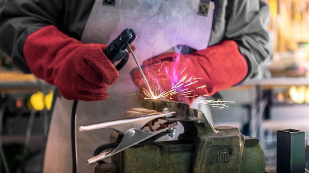 Craftsman working with arc welding machine in workshop Piece of iron with spark